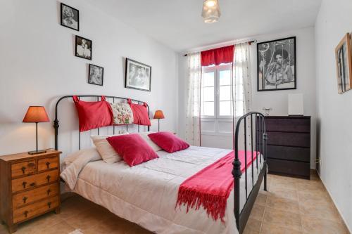 a bedroom with a bed with red pillows at Villa Rústica con piscina privada in Tías