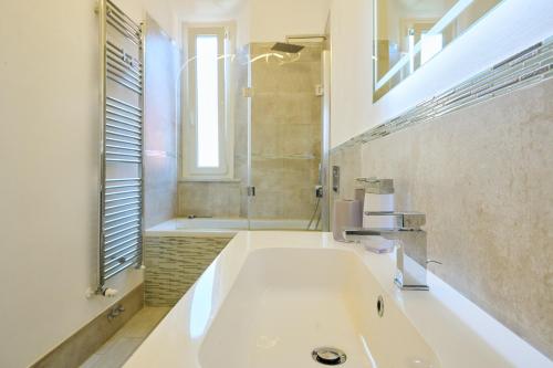 a white bathroom with a sink and a shower at Holy days in Piombino