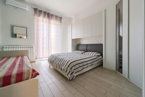 a white bedroom with a bed and a window at Holy days in Piombino
