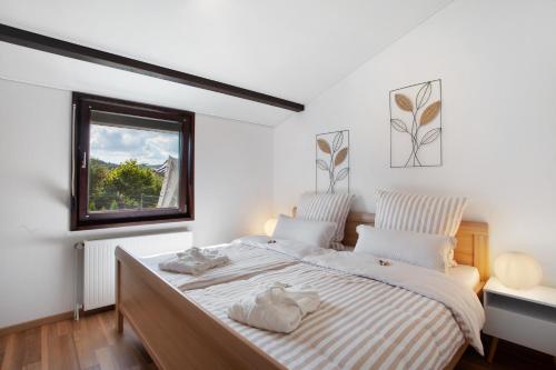 a bedroom with a large bed with a window at Ferienhaus Sauerland am Hennesee in Meschede