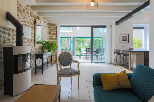 a living room with a blue couch and a fireplace at Gite les coquelicots Proche mer in Paimpol