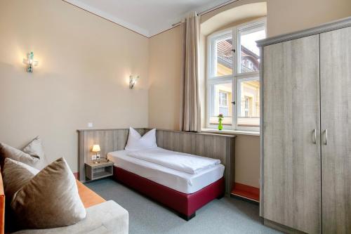 a small bedroom with a bed and a window at Luckau Appartements 1695 in Luckau