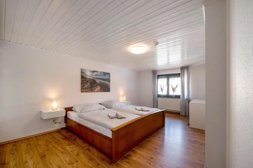 a bedroom with a large bed in a room at Haus Seezeit in Freilingen