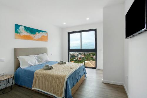 a bedroom with a bed and a large window at Villa Angela in Funchal