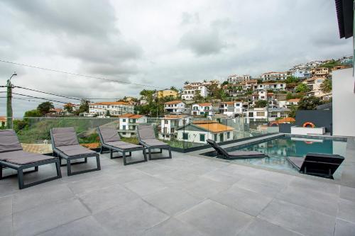 a balcony with chairs and a view of a city at Villa Angela in Funchal
