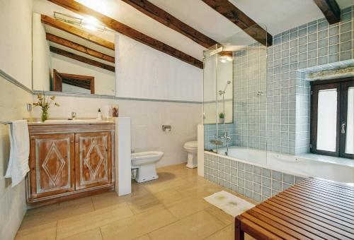 a bathroom with a tub and a toilet and a sink at Cadernera in Búger