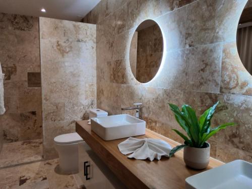 a bathroom with two sinks and a toilet at Sol de Arena Beachfront, Las Terrenas in Las Terrenas