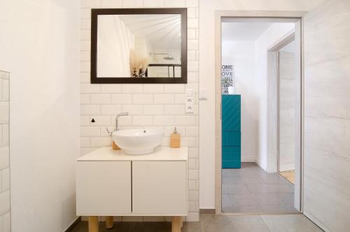 a white bathroom with a sink and a mirror at Casa Ruf in Orsingen-Nenzingen