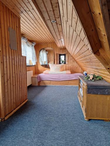 ein Schlafzimmer mit einem Bett in einem Holzzimmer in der Unterkunft Bei Oparius in Ganderkesee