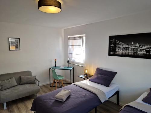 a bedroom with a bed and a chair and a window at Wohnung Barbarossa in Rommelhausen