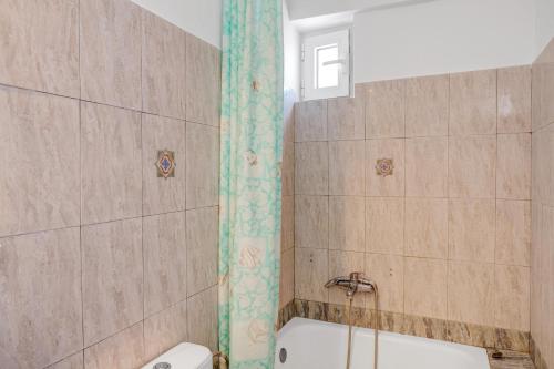 a bathroom with a shower and a tub and a toilet at Athina seaside in Kardamaina