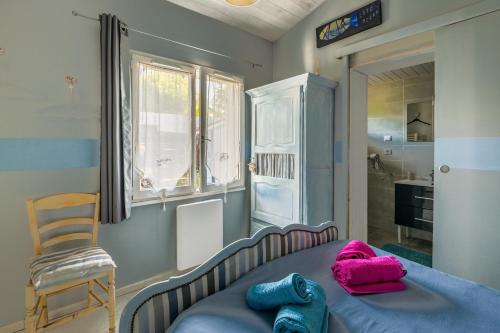 a bedroom with a bed with pink and blue towels on it at Maison agréable et tranquille in Gujan-Mestras