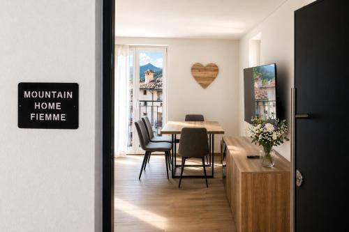 a room with a table and chairs and a dining room at MOUNTAIN HOME Fiemme - Nuovo, Balconi e Garage in Castello di Fiemme