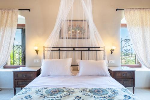 a bedroom with a bed and two windows at Old manor house in Syvota