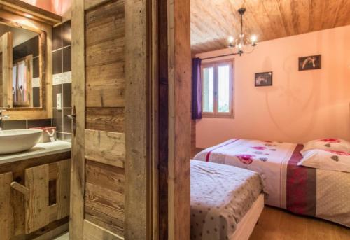 a bathroom with two beds and a sink in a room at Ferme Le Coup d'Oeil in Taninges