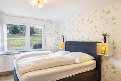 a bedroom with a large bed with a window at Haus am Candelaber in Altenbergen