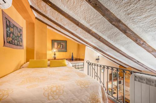 a bedroom with a bed with yellow walls at Tomillo in Hinojares