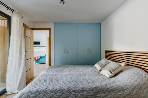 a bedroom with a large bed with blue cabinets at Domki nad Krasnem in Krasne