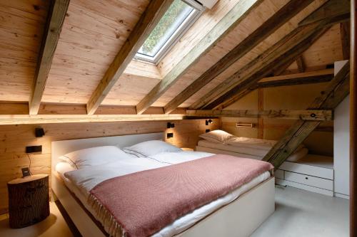 an attic bedroom with two beds and a window at Ferienwohnung im Gehöft in Müllheim