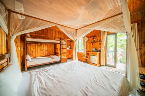 a bedroom with a large bed in a wooden room at Jungle Boss Travel Lodge in Phong Nha