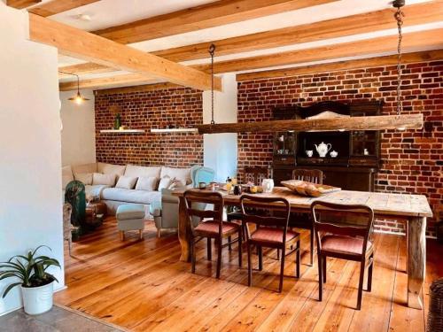 a living room with a brick wall and a table and chairs at Ferienhaus am Rande des Spreewald in Heinersbrück