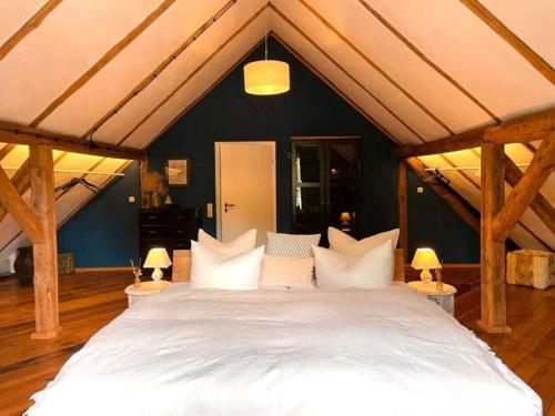 a large bed with white pillows in a room at Ferienhaus am Rande des Spreewald in Heinersbrück
