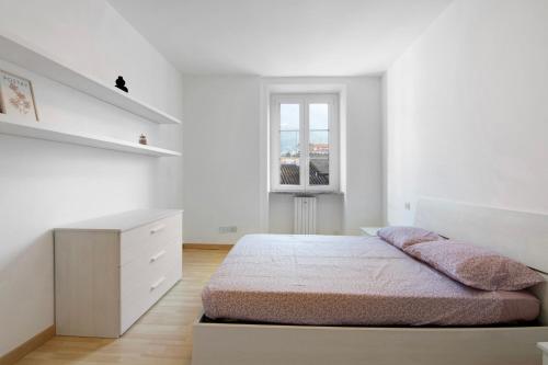 a white bedroom with a bed and a desk at Greta House in Colico