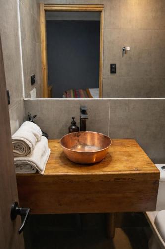 a bathroom with a wooden bowl sink on a wooden counter at Chagual Los Vilos Lodging in Los Vilos