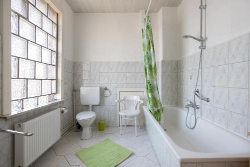 a bathroom with a tub and a toilet and a sink at Die Kleine Ferienvilla in Wesselburen