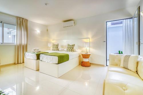 a white bedroom with a bed and a couch at Villa Ginevra in Arona