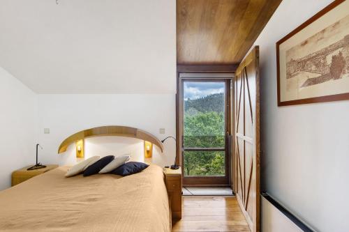 a bedroom with a large bed and a window at Quinta das Cavadas in Canedo