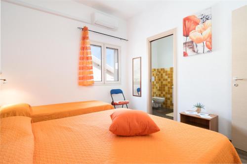 a hotel room with two beds and a mirror at Holiday vista Montagna in Cala Gonone