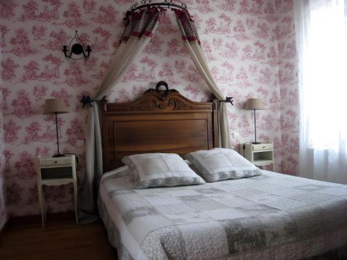 a bedroom with a bed with pink floral wallpaper at Les Charmilles in Charny-sur-Meuse