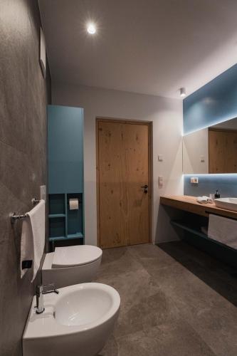 a bathroom with a toilet and a sink at Valentinerhof Apt Aqua in San Michele