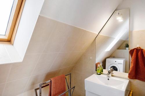 a bathroom with a sink and a washing machine at Wellness Ferienwohnung Müller in Rostock