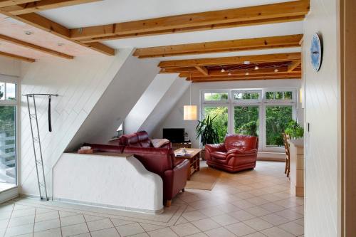 a living room with red leather chairs and a table at Wellness Ferienwohnung Müller in Rostock
