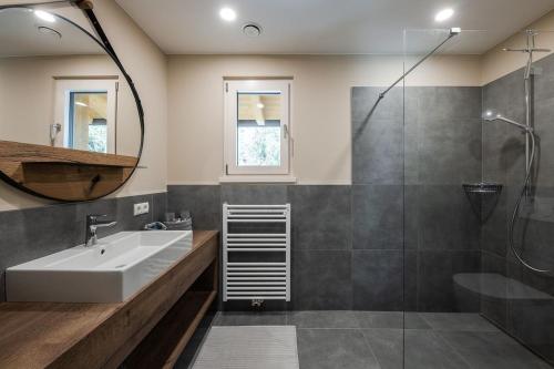 a bathroom with a sink and a shower at Piz Aich Natur Chalet Panorama in Avelengo