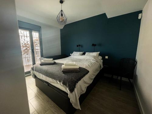 a bedroom with a large bed with a blue wall at Atico Bremadito in Torrox Costa