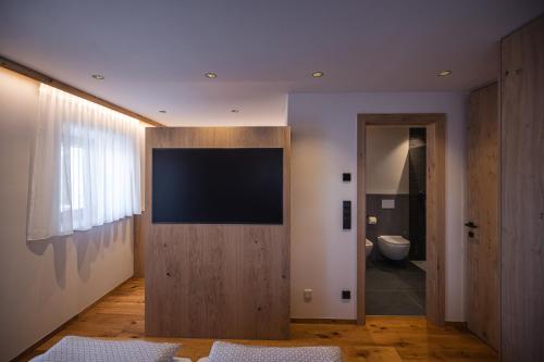 a living room with a flat screen tv on a wall at Rueper Hof Chalet Pracken in Valdaora