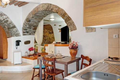 a kitchen with a table and chairs and a sink at Maria in the castle Kea in Ioulis