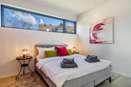 a bedroom with a bed and a large window at Design Apartment Mettnaublick in Radolfzell am Bodensee
