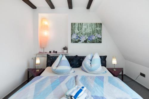 a bedroom with a bed with blue and white pillows at Ferienwohnung Vierheller in Lauterbach