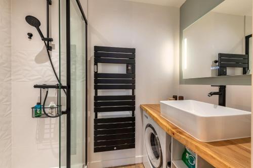 a bathroom with a sink and a washing machine at Appartement du Théâtre Morlaix in Morlaix