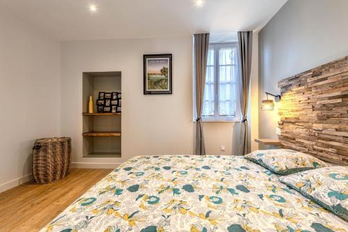 a bedroom with a bed and a brick wall at Appartement du Théâtre Morlaix in Morlaix