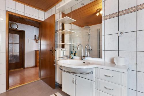 ein weißes Badezimmer mit Waschbecken und Dusche in der Unterkunft Brown in Bad König