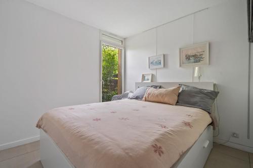 a white bedroom with a bed and a window at Terrasse de Malissol in Vienne