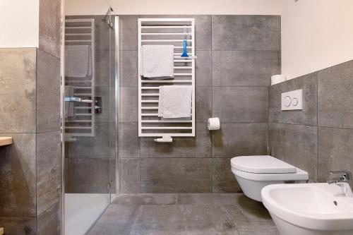 a bathroom with a shower and a toilet and a sink at Furnerhof Apt Stearnzauber in Collepietra