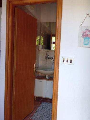 a bathroom with a sink and a mirror at Apartman Mira in Karlobag