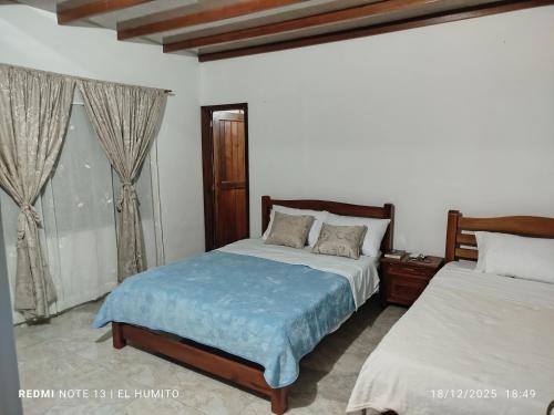 a bedroom with two beds and a window at Villa ceiba in Guaduas
