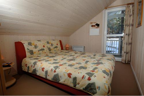 a bedroom with a bed with a comforter and a window at Ferienhaus Seebär in Baabe